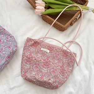 Détail du sac cabas floral montrant la texture en toile et les anses en cuir rose