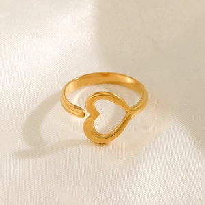Minimalist gold heart-shaped open ring made of stainless steel on beige silk fabric