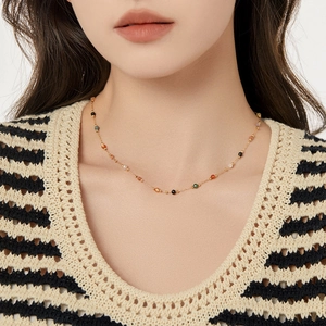 Minimalist gold collar necklace with colorful natural stone beads on a model