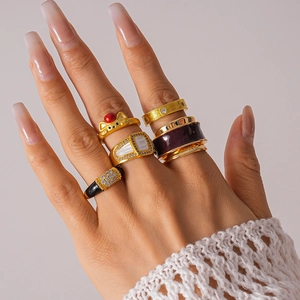 Detail view of vintage gold plated rings with purple enamel and zircon inlay on hand