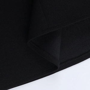 Detail of double-stitched hem and premium black fabric texture on the strapless dress