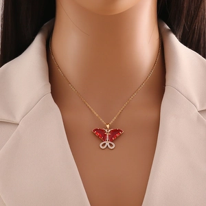 Elegant gold butterfly necklace with red zircon pendant on model for stylish look