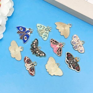 Set of 12 vintage enamel butterfly charms with stars and moon motifs on blue background