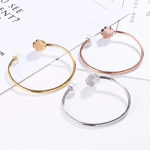 Three-piece flower and pearl open bangle set in gold, rose gold, and silver finishes