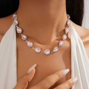 Detail of pink pear-shaped gemstone necklace with crystal halo on neck model
