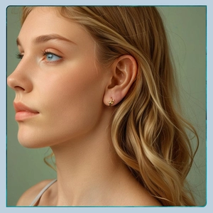 Close-up of minimalist gold star-shaped stud earring worn on model for a modern look