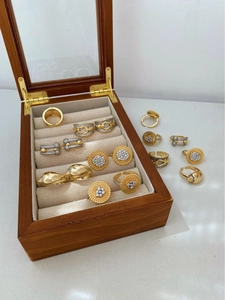 Classic 18K gold plated rings with zircon stones displayed on a wood jewelry box
