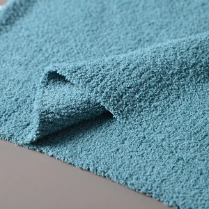 Close-up of thick blue chenille knit fabric texture with soft granular luxury weave