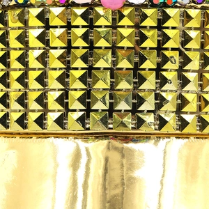 Macro detail of gold pyramid studs and colorful beads on the flat top bridal party hat