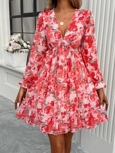 Detail of pink floral print dress with V-neck and ruffled hem on elegant long sleeves
