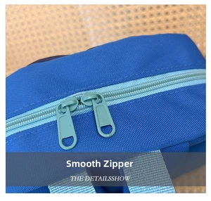 Detailed close-up of smooth green double zippers on durable blue canvas backpack fabric