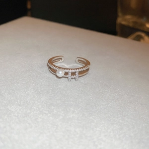 Macro shot of silver-tone double-layer butterfly ring with H letter and pearl detail