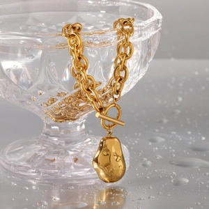 Collier doré avec pendentif galet, chaîne à gros maillons et fermoir en T