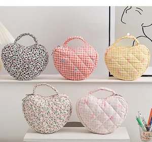 Collection of floral and checkered quilted heart-shaped makeup bags in a cozy setting