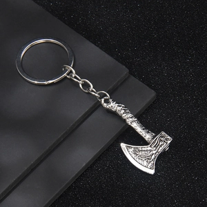 Silver Viking double axe metal keychain with intricate Nordic engraving on black background