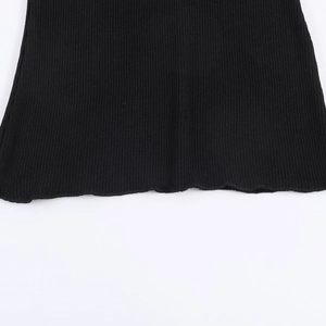 Detailansicht aus schwarzem Rippstrick mit elegantem gewelltem Saum und Naht