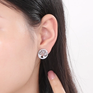 Detailed view of silver tree of life earrings worn on model for stylish daily accessory