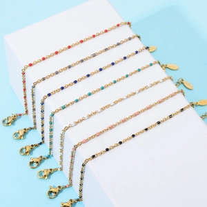 Detail view of colorful enamel bead bracelets on gold plated chains in various colors