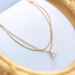 Bracelet double chaîne dorée design français avec zircon brillant sur velours bleu