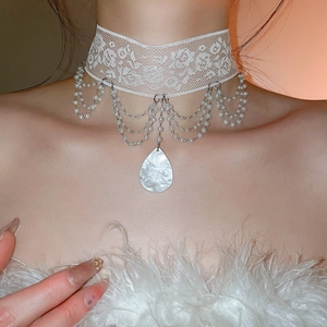 Gros plan détaillé du ras-du-cou en dentelle avec glands de perles et pendentif