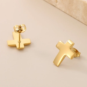 Detailed close-up of 18K gold plated stainless steel cross stud earrings with butterfly back