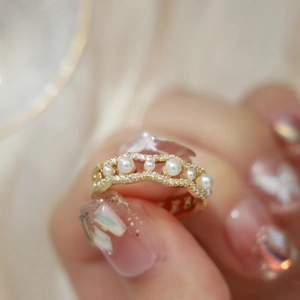 Luxurious gold wavy open ring featuring white pearls and shimmering zircons for women