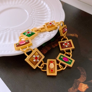 Macro detail of vintage gold bracelet with colorful enamel inlay and sparkling rhinestones