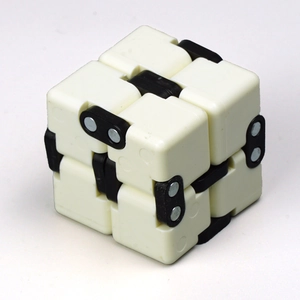 Macro detail of white Infinity Cube with black hinges and metal rivets for stress relief