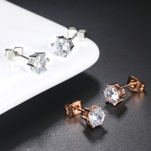 Detailed view of silver and rose gold six-prong round zircon stud earrings