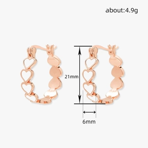 Détail des boucles d'oreilles cœur en or rose montrant la hauteur de 21mm et le poids
