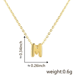 Macro detail of gold letter M pendant with dimensions 0.34x0.26 inch and 0.6g weight