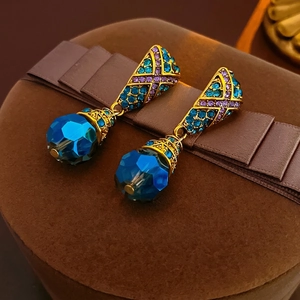 Vintage bohemian gold earrings with navy blue crystals and rhinestones on velvet box