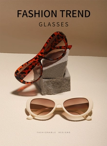Close-up of wide oval sunglasses in leopard and ivory frames with brown gradient lenses