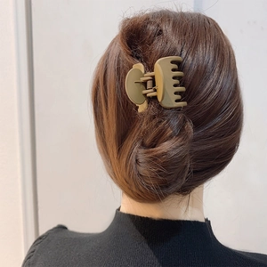 Back view of a woman wearing a brown hair claw clip for a high ponytail hairstyle