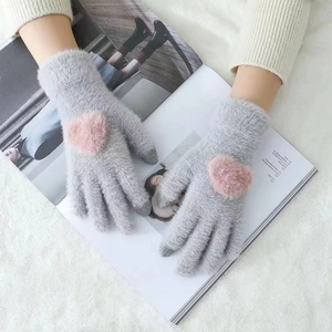 Close-up of grey plush winter gloves featuring a pink heart detail on a soft background