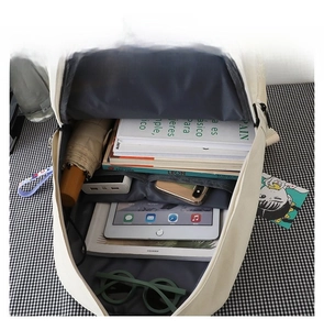 Detail view of the spacious inner compartment holding a tablet, books, and umbrella