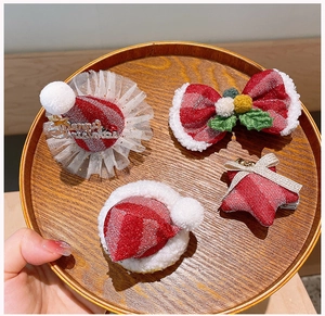 Gros plan sur un ensemble de 4 pinces à cheveux de Noël avec chapeaux en peluche et nœuds