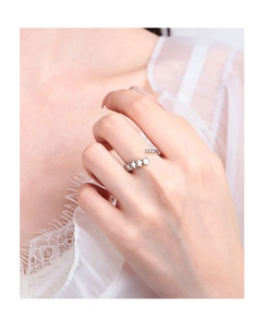 Close-up of three silver star elements on a minimalist open ring worn by a model