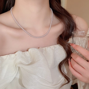 Close-up of elegant French style pearl necklace on model with soft lighting details