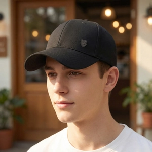 Classic black men's baseball cap with a metal emblem shown in an outdoor setting