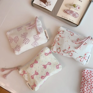 Detailed overhead view of four floral cotton zipper pouches with simple wish brand tags