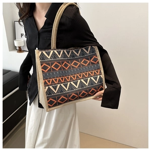 Detailed close-up of ethnic geometric woven tote bag with orange and black patterns