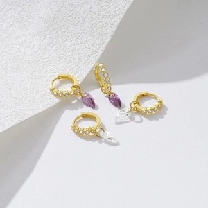 Detailed macro view of S925 sterling silver gold earrings with teardrop zirconia charms