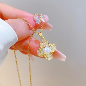 Detailed close-up of a vintage gold pendant with drop pearl and zircon accents on a chain