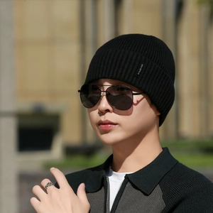 Classic black ribbed knit beanie for winter featuring a minimalist side woven label