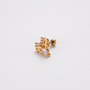 Macro shot of crown-shaped gold ear stud with sparkling cubic zirconia inlay