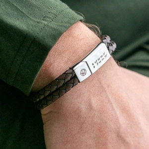 Close-up of double-layer brown braided leather bracelet with engraved magnetic clasp