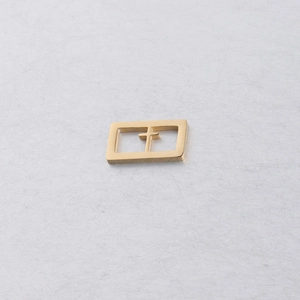Gros plan sur un pendentif rectangulaire doré en acier inoxydable avec croix évidée pour DIY
