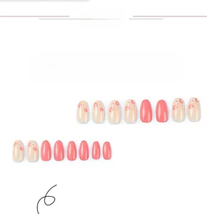 Detail of oval pink press-on nails featuring glossy finish and floral hand-painted art
