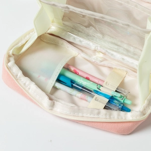Detail view of pink and beige canvas pencil case with transparent divider and mesh pockets